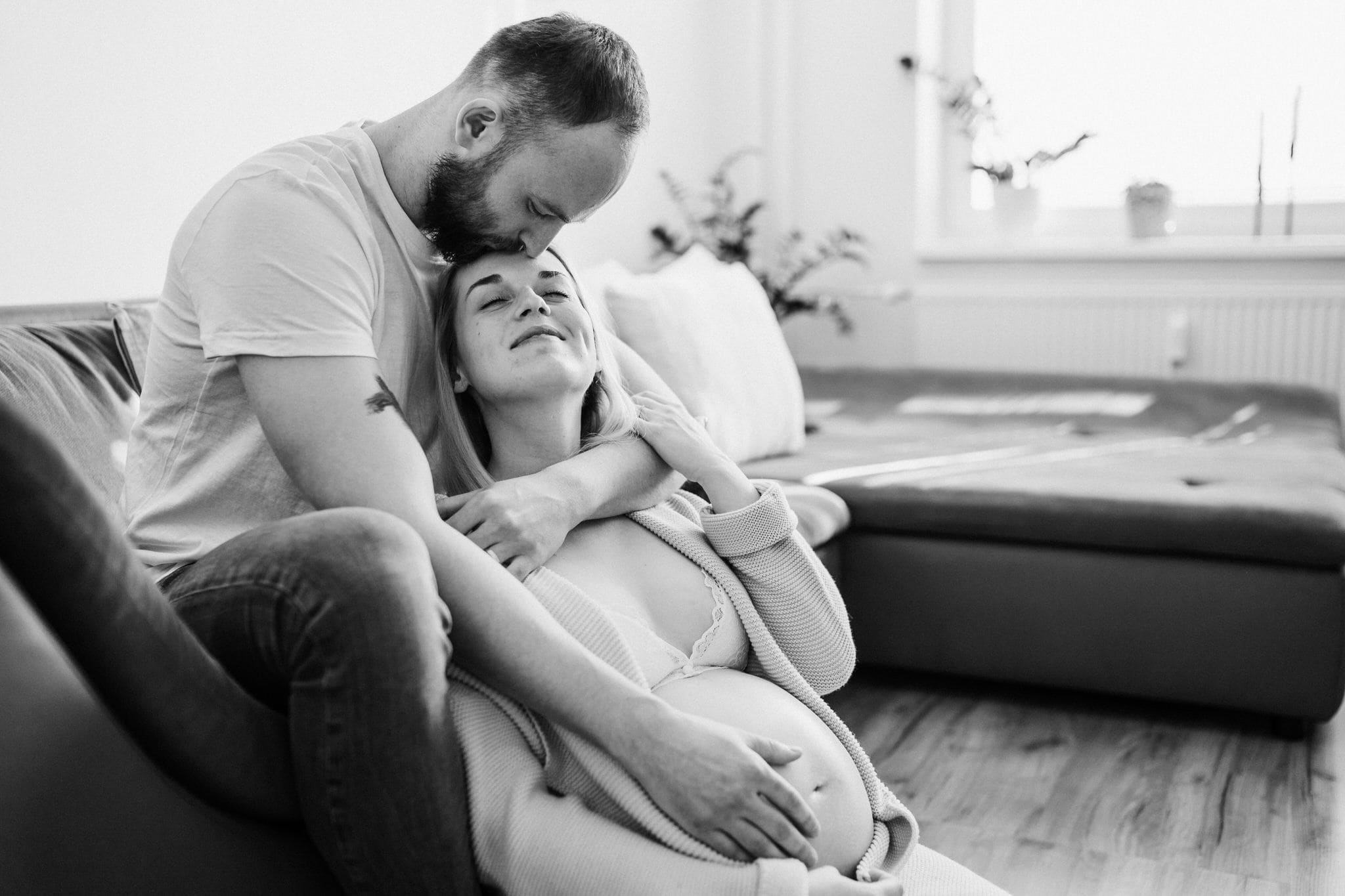 těhotená žena v objetí partnera na těhotenských fotkách doma v obýváku-fotografka Veronika Kovačková-Žďár nad Sázavou-Vysočina